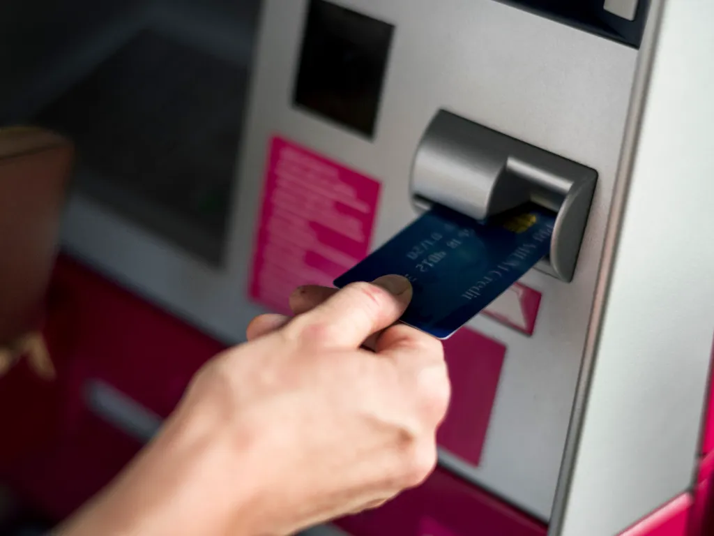 Una persona retira dinero de un cajero automático