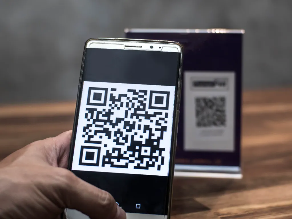 Una persona paga con su celular mediante código QR